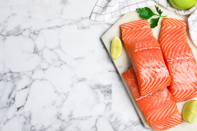 Top view of fresh raw salmon with lime and parsley on white marble table, space for text. Fish delicacy Photo of Top view of fresh raw salmon with lime and parsley on white marble table, space for text. Fish delicacy