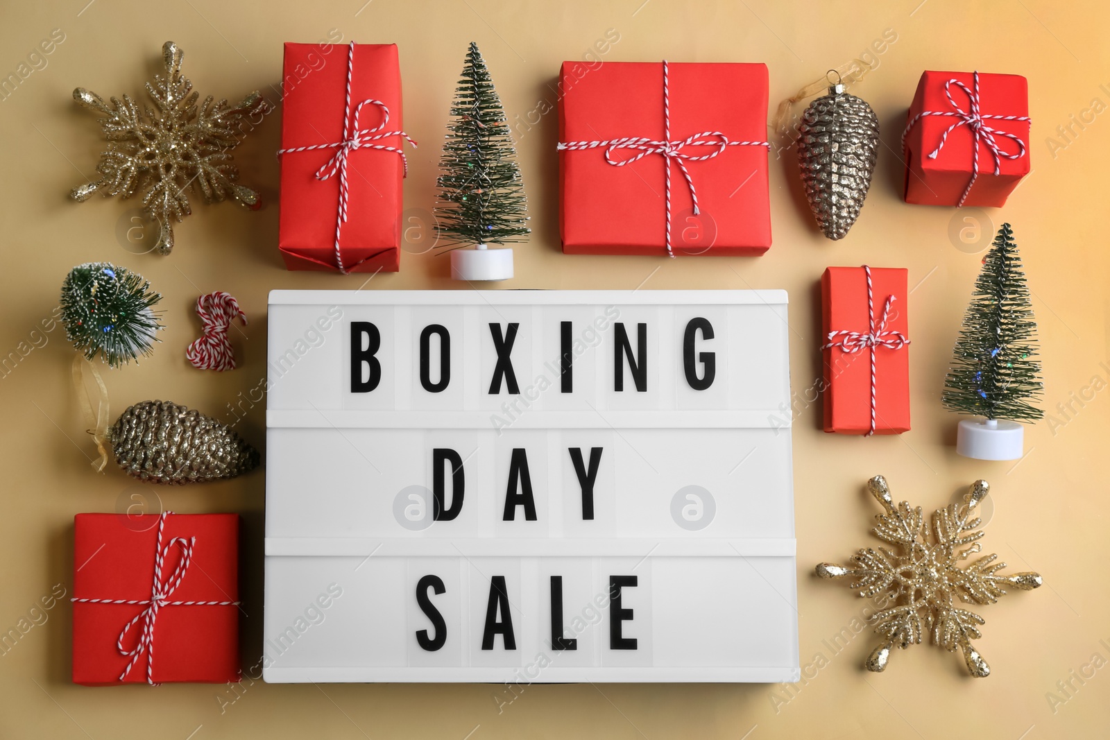 Lightbox with phrase BOXING DAY SALE and Christmas decorations on beige background, flat lay Photo of Lightbox with phrase BOXING DAY SALE and Christmas decorations on beige background, flat lay