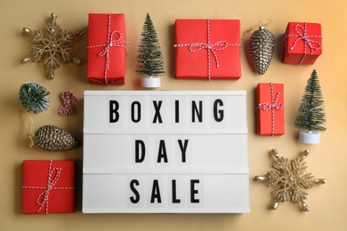 Lightbox with phrase BOXING DAY SALE and Christmas decorations on beige background, flat lay Photo of Lightbox with phrase BOXING DAY SALE and Christmas decorations on beige background, flat lay