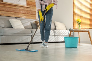 Woman cleaning floor with mop at home, closeup Photo of Woman cleaning floor with mop at home, closeup