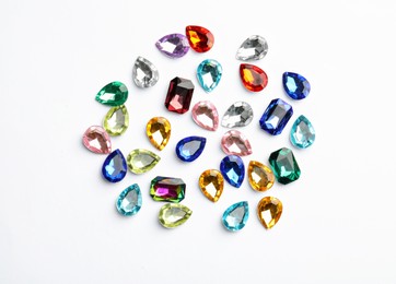 Different beautiful gemstones on white background, top view Image of Different beautiful gemstones on white background, top view