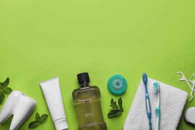 Flat lay composition with mouthwash and other oral hygiene products on light green background. Space for text Photo of Flat lay composition with mouthwash and other oral hygiene products on light green background. Space for text