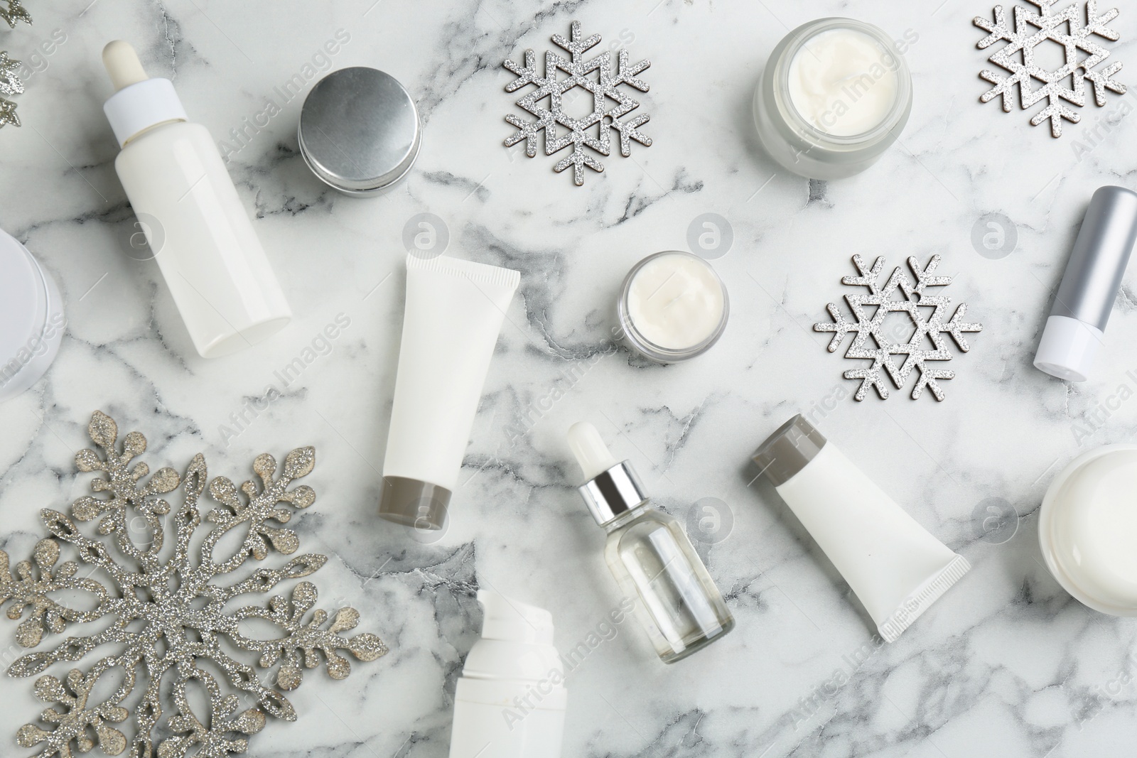 Flat lay composition with different cosmetic products on white marble table. Winter care Photo of Flat lay composition with different cosmetic products on white marble table. Winter care