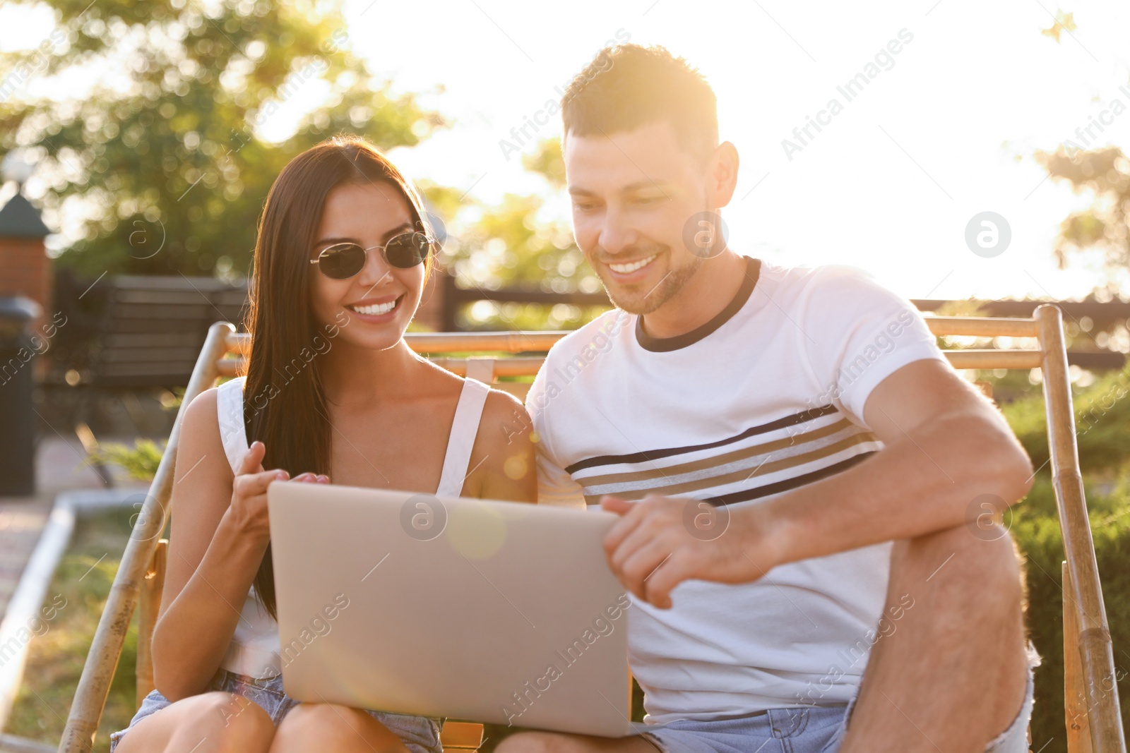 Happy couple with laptop resting together outdoors Image of Happy couple with laptop resting together outdoors