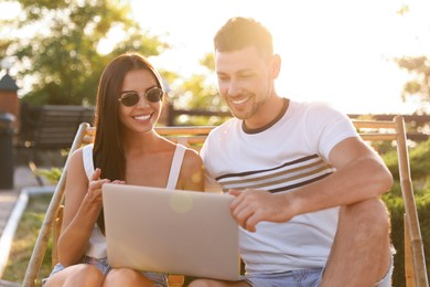 Happy couple with laptop resting together outdoors Image of Happy couple with laptop resting together outdoors