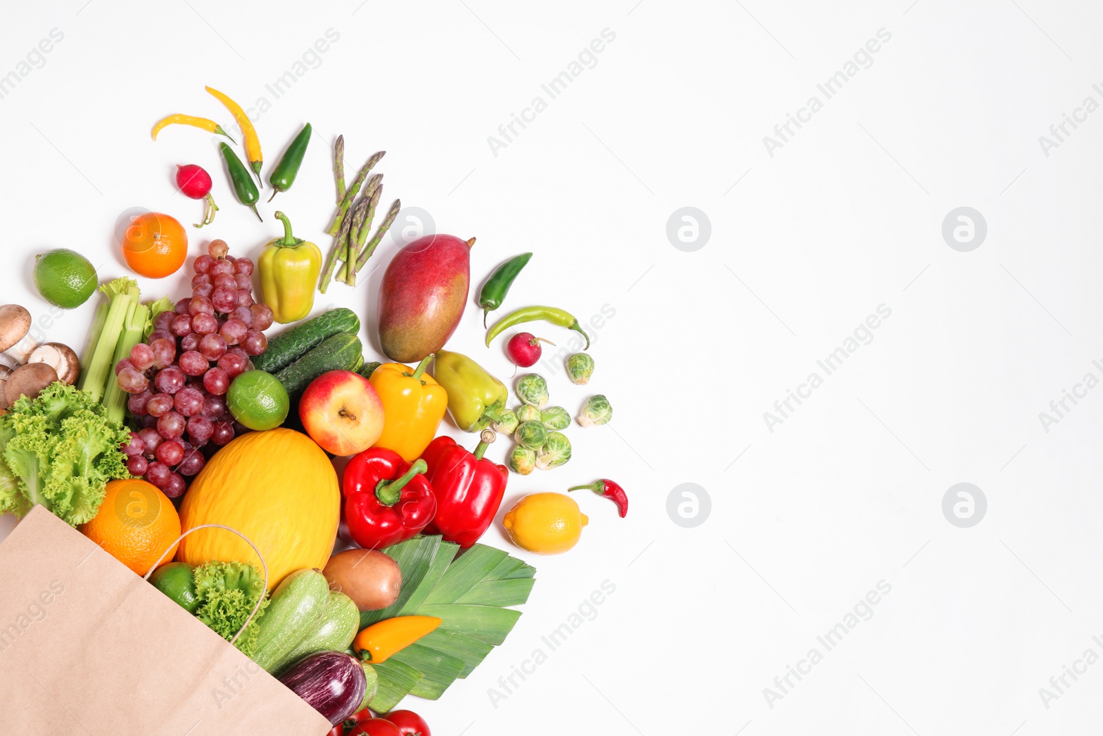 Paper bag with assortment of fresh organic fruits and vegetables on white background, top view Photo of Paper bag with assortment of fresh organic fruits and vegetables on white background, top view
