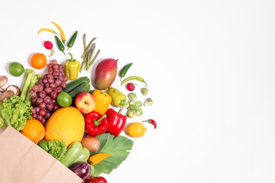 Paper bag with assortment of fresh organic fruits and vegetables on white background, top view Photo of Paper bag with assortment of fresh organic fruits and vegetables on white background, top view