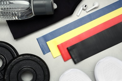 Flat lay composition with fitness elastic bands on light background Photo of Flat lay composition with fitness elastic bands on light background
