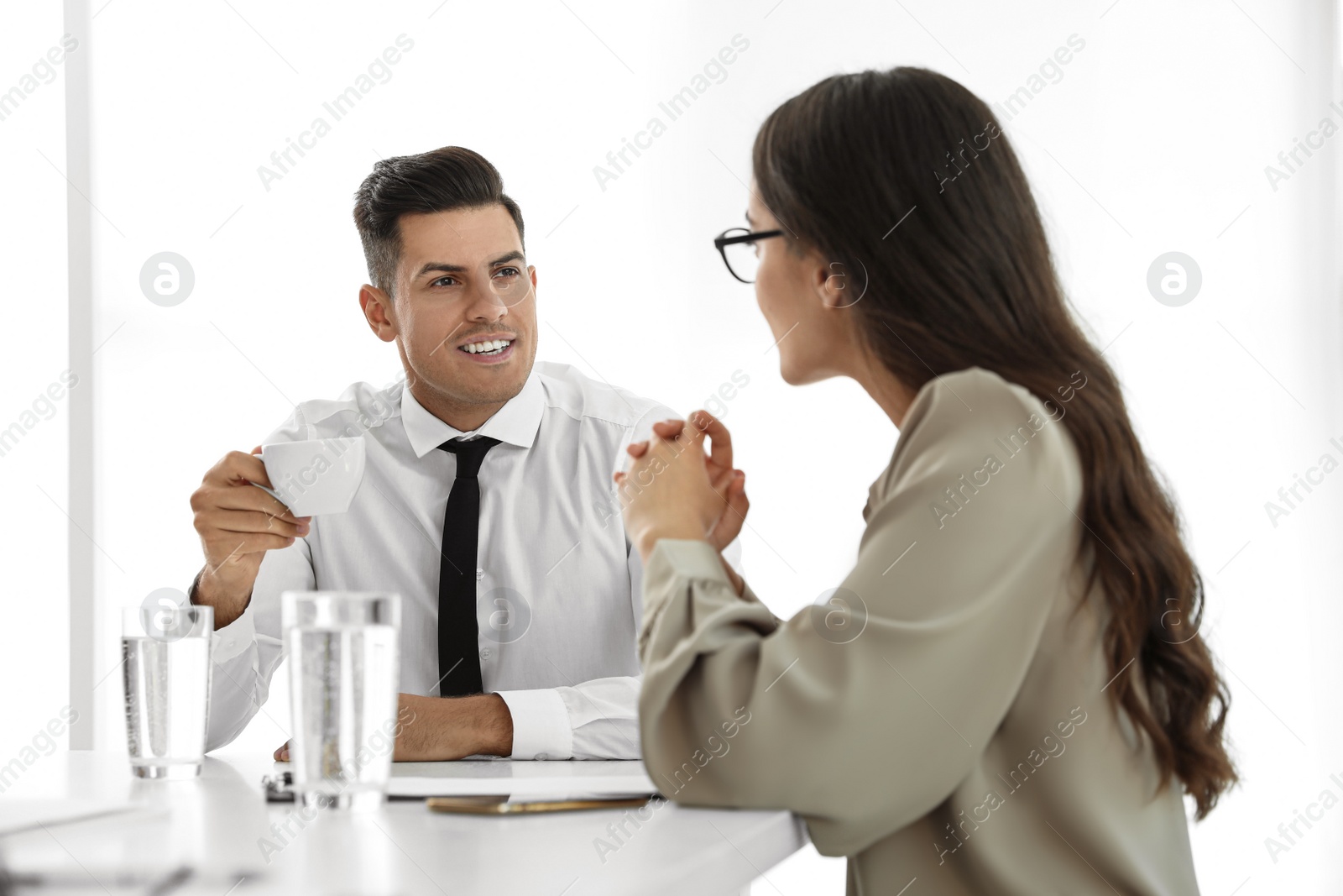Office employees talking at table during meeting Photo of Office employees talking at table during meeting