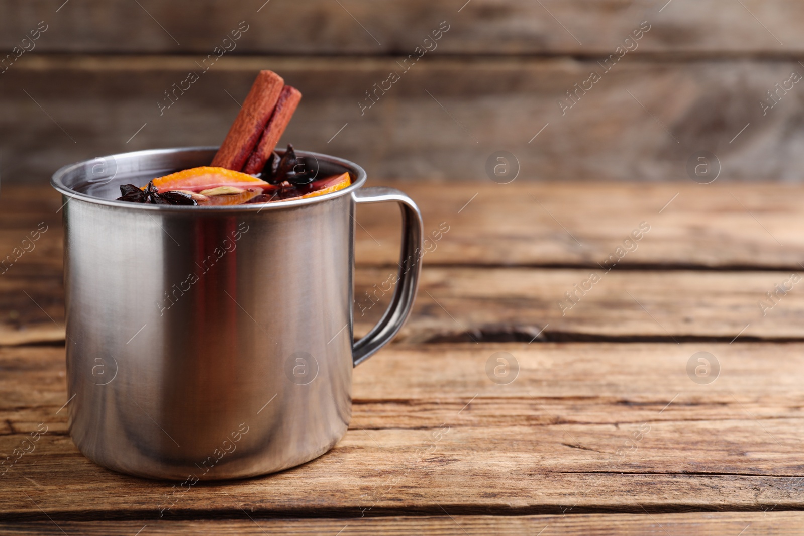 Aromatic mulled wine on wooden table, space for text Photo of Aromatic mulled wine on wooden table, space for text
