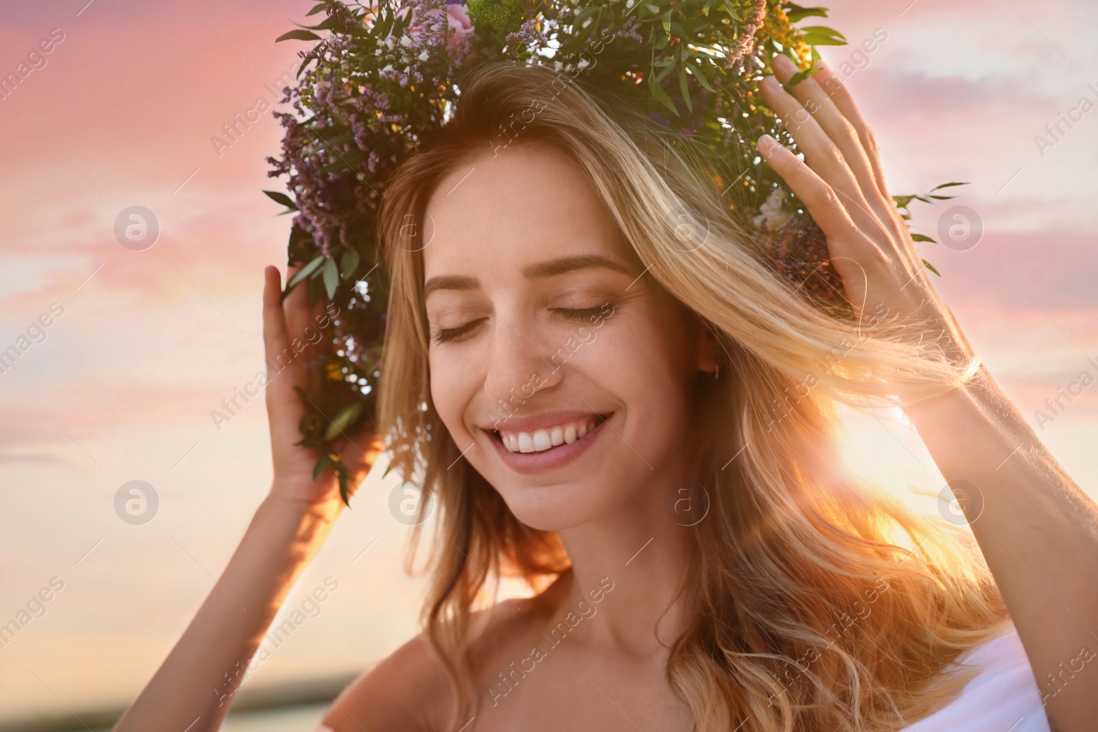 Young woman wearing wreath made of beautiful flowers outdoors Photo of Young woman wearing wreath made of beautiful flowers outdoors