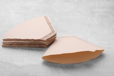 Many paper coffee filters on grey table Photo of Many paper coffee filters on grey table