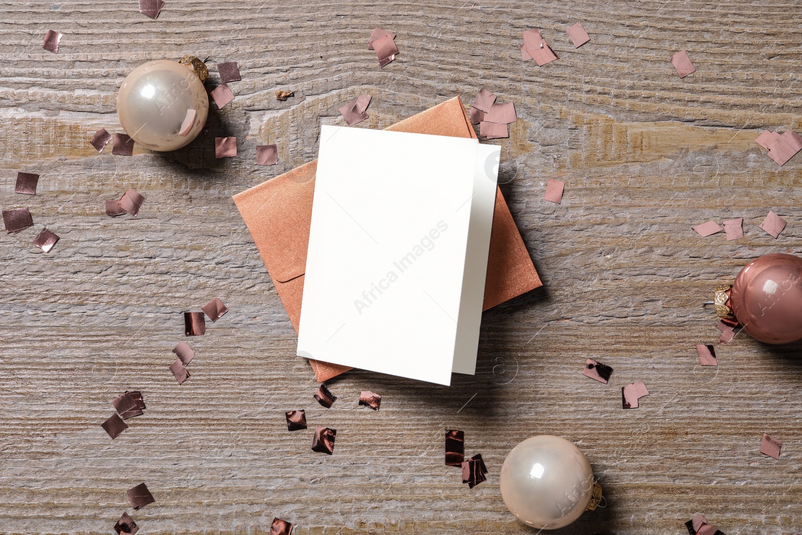 Blank greeting card, envelope and Christmas balls on wooden table, flat lay. Space for text Photo of Blank greeting card, envelope and Christmas balls on wooden table, flat lay. Space for text