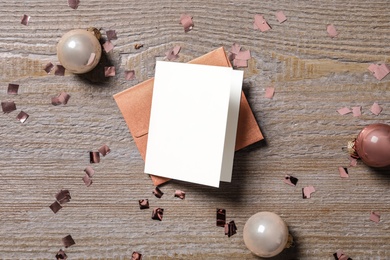 Blank greeting card, envelope and Christmas balls on wooden table, flat lay. Space for text Photo of Blank greeting card, envelope and Christmas balls on wooden table, flat lay. Space for text