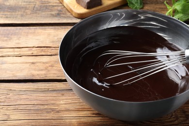 Delicious chocolate cream and whisk in bowl on wooden table, closeup. Space for text Photo of Delicious chocolate cream and whisk in bowl on wooden table, closeup. Space for text