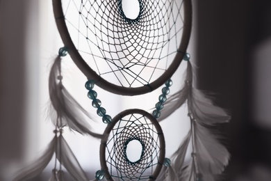Beautiful dream catcher hanging against blurred background, closeup Photo of Beautiful dream catcher hanging against blurred background, closeup