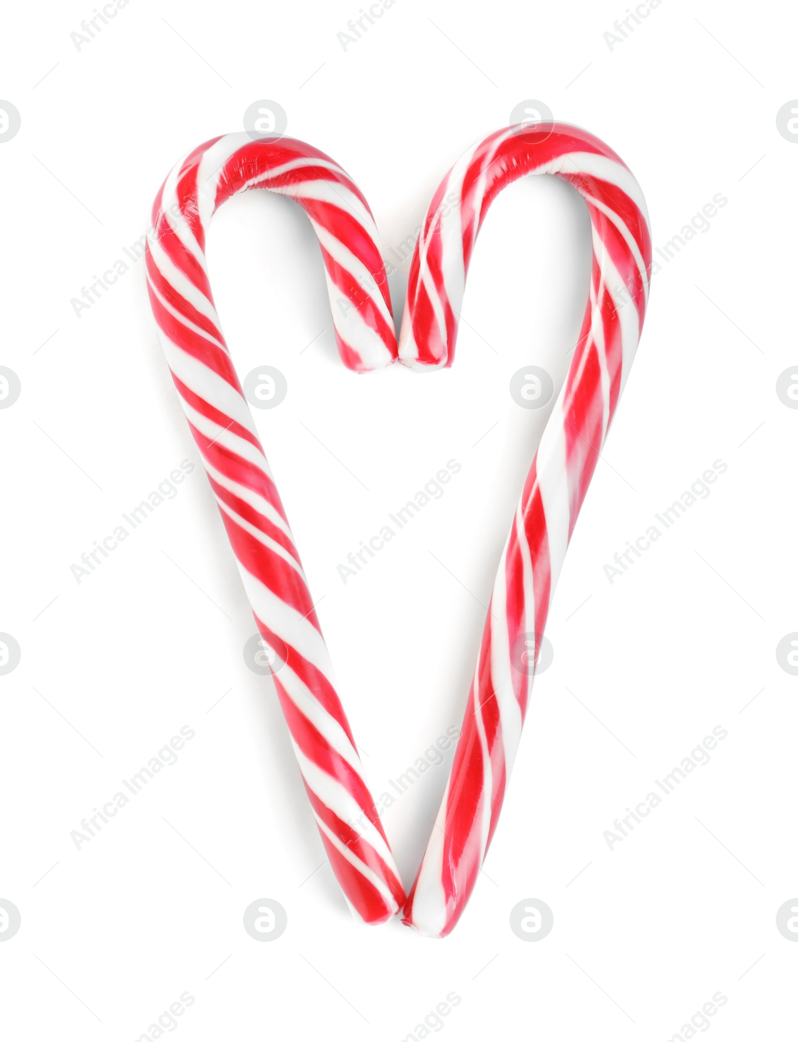Heart made of Christmas candy canes on white background, top view Photo of Heart made of Christmas candy canes on white background, top view