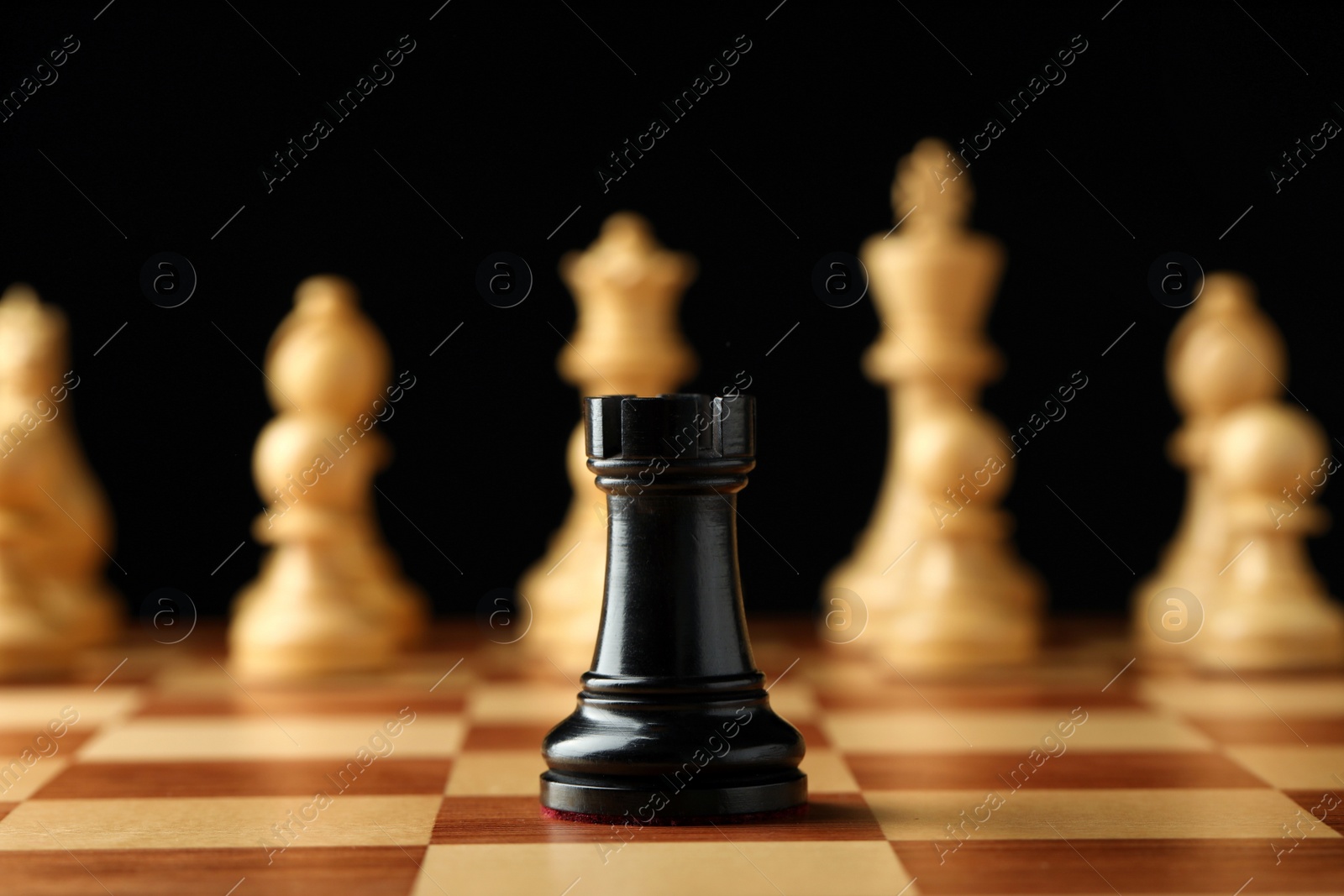 Chessboard with game pieces on black background Photo of Chessboard with game pieces on black background