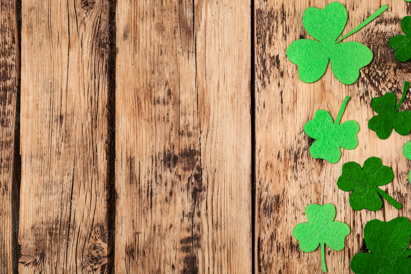 Decorative clover leaves on wooden table, flat lay with space for text. Saint Patrick's Day celebration Photo of Decorative clover leaves on wooden table, flat lay with space for text. Saint Patrick's Day celebration