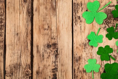 Decorative clover leaves on wooden table, flat lay with space for text. Saint Patrick's Day celebration Photo of Decorative clover leaves on wooden table, flat lay with space for text. Saint Patrick's Day celebration
