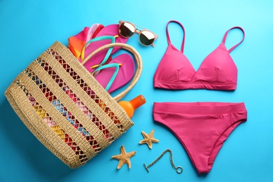 Beautiful pink bikini and beach accessories on light blue background, flat lay Photo of Beautiful pink bikini and beach accessories on light blue background, flat lay