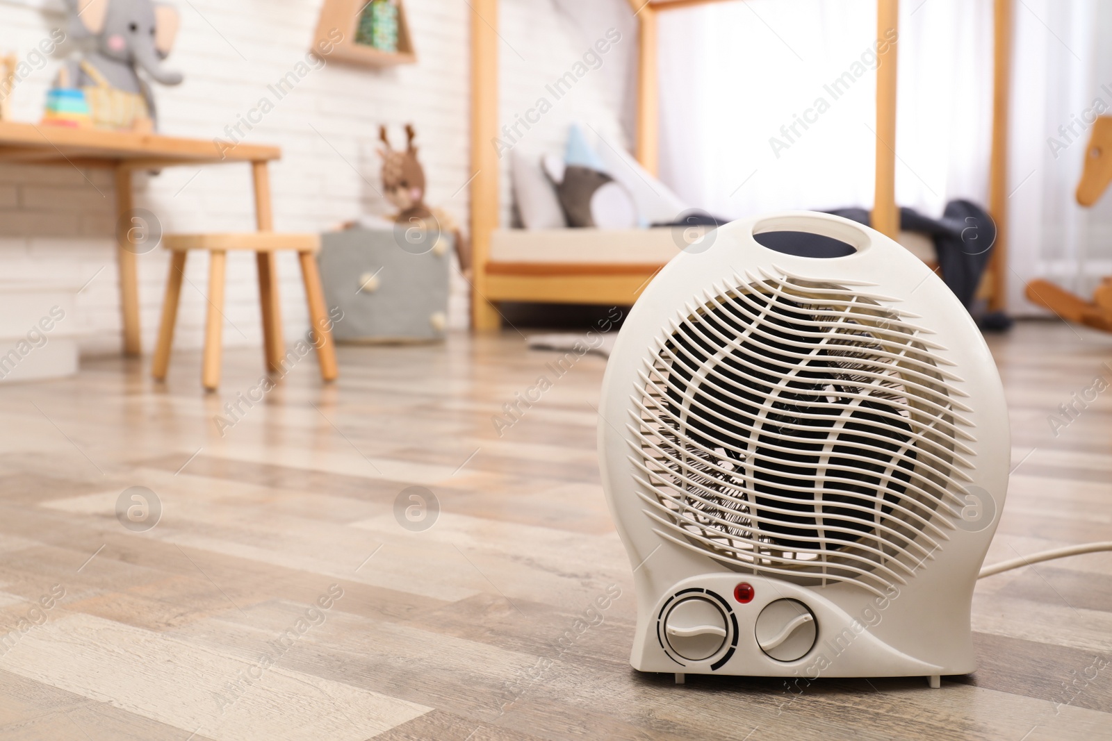 Modern electric fan heater on floor at home. Space for text Photo of Modern electric fan heater on floor at home. Space for text