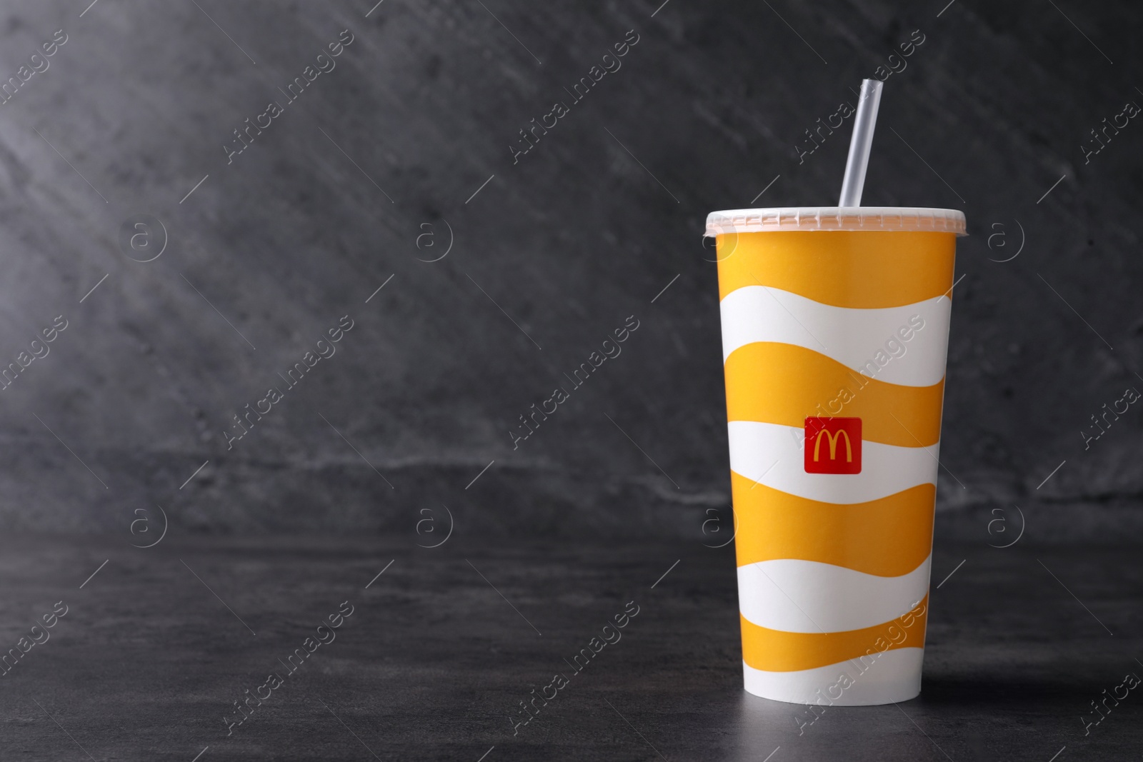 MYKOLAIV, UKRAINE - AUGUST 12, 2021: Cold McDonald's drink on grey table. Space for text Photo of MYKOLAIV, UKRAINE - AUGUST 12, 2021: Cold McDonald's drink on grey table. Space for text