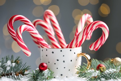 Many sweet candy canes in cup against blurred festive lights. Traditional Christmas treat Photo of Many sweet candy canes in cup against blurred festive lights. Traditional Christmas treat