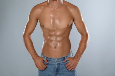 Photo of Shirtless man with slim body on grey background, closeup