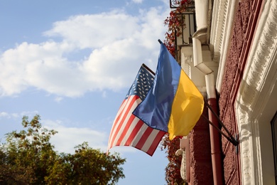 Flags of Ukraine and USA on building facade Photo of Flags of Ukraine and USA on building facade