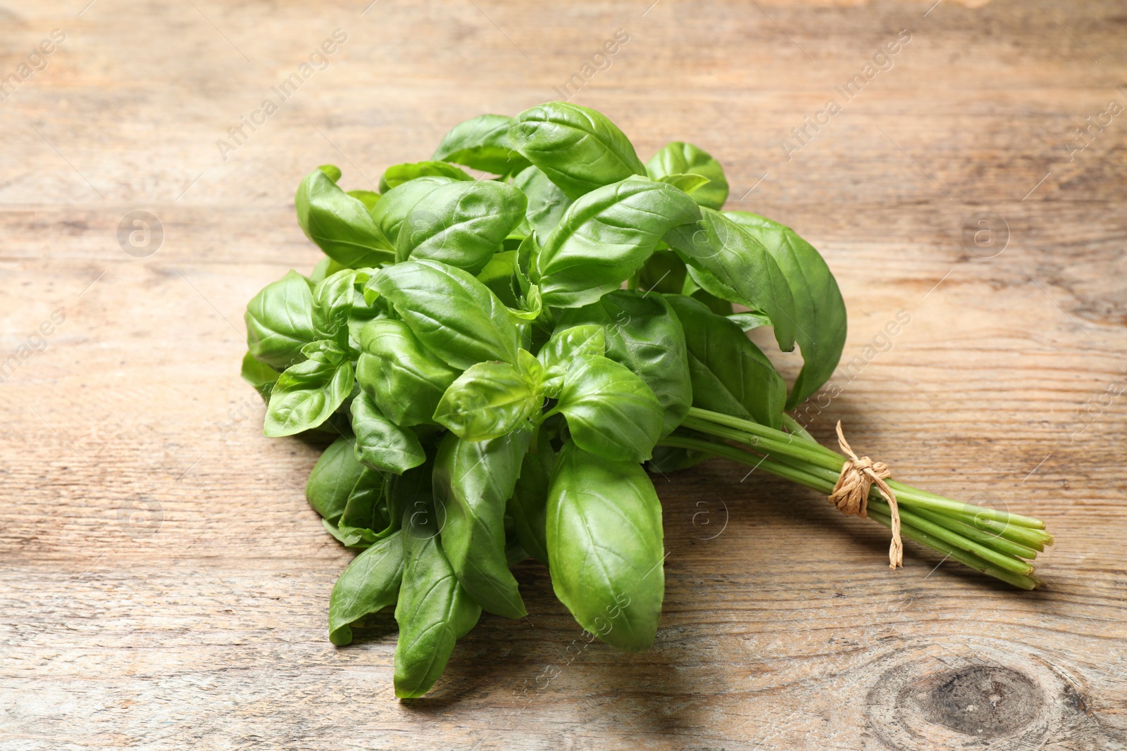 Photo of Bunch of fresh basil on wooden table
