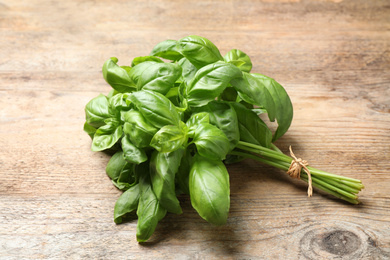 Photo of Bunch of fresh basil on wooden table