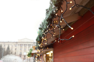 Christmas fair stall with string lights outdoors, closeup Photo of Christmas fair stall with string lights outdoors, closeup
