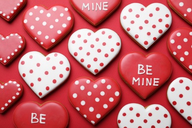 Photo of Decorated heart shaped cookies on red background, flat lay. Valentine's day treat