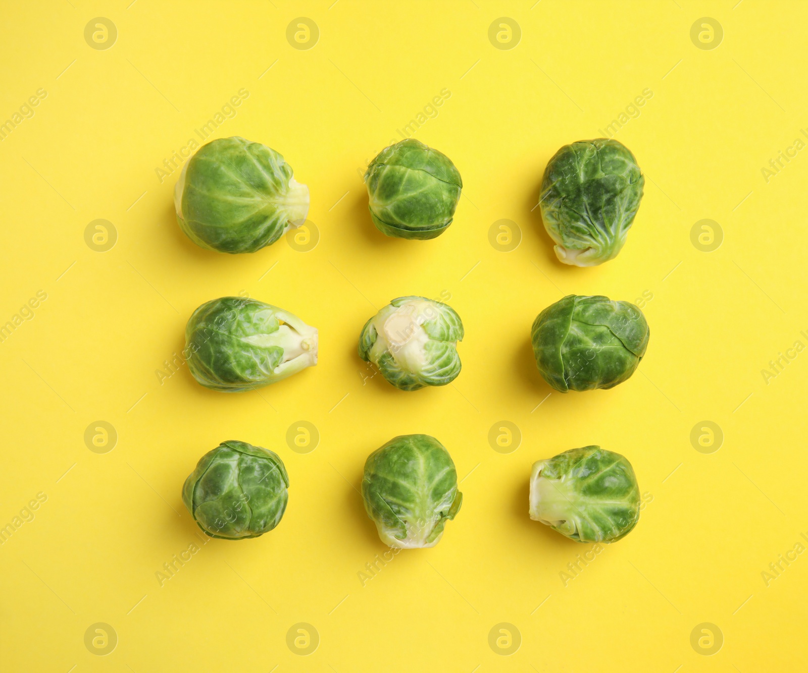 Fresh Brussels sprouts on yellow background, flat lay Photo of Fresh Brussels sprouts on yellow background, flat lay