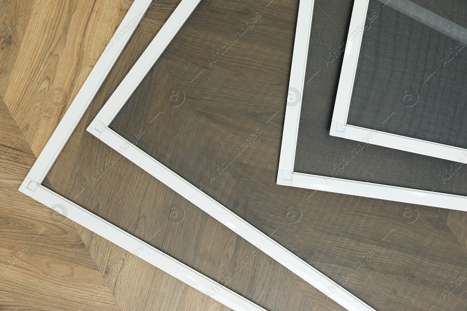 Set of window screens on wooden floor, flat lay Photo of Set of window screens on wooden floor, flat lay
