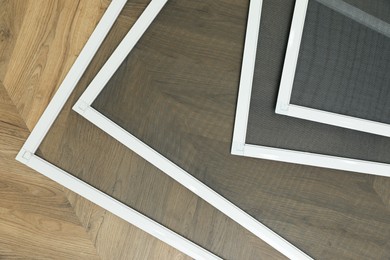 Set of window screens on wooden floor, flat lay Photo of Set of window screens on wooden floor, flat lay