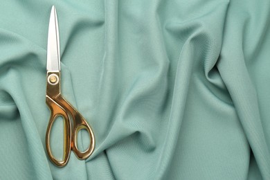 Scissors on green fabric, top view. Space for text Photo of Scissors on green fabric, top view. Space for text