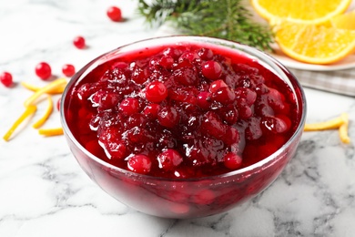 Bowl of cranberry sauce on white marble table Photo of Bowl of cranberry sauce on white marble table