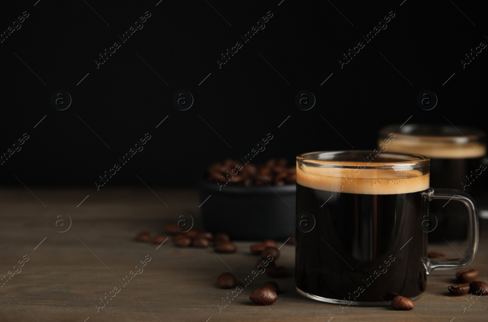 Cups of hot aromatic coffee and roasted beans on wooden table. Space for text Photo of Cups of hot aromatic coffee and roasted beans on wooden table. Space for text