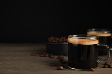Cups of hot aromatic coffee and roasted beans on wooden table. Space for text Photo of Cups of hot aromatic coffee and roasted beans on wooden table. Space for text