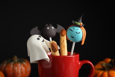Different cake pops in cup decorated as monsters, closeup. Halloween treat Photo of Different cake pops in cup decorated as monsters, closeup. Halloween treat