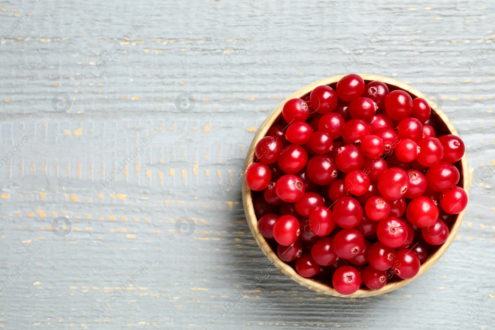 Tasty ripe cranberries on grey wooden table, top view. Space for text Photo of Tasty ripe cranberries on grey wooden table, top view. Space for text