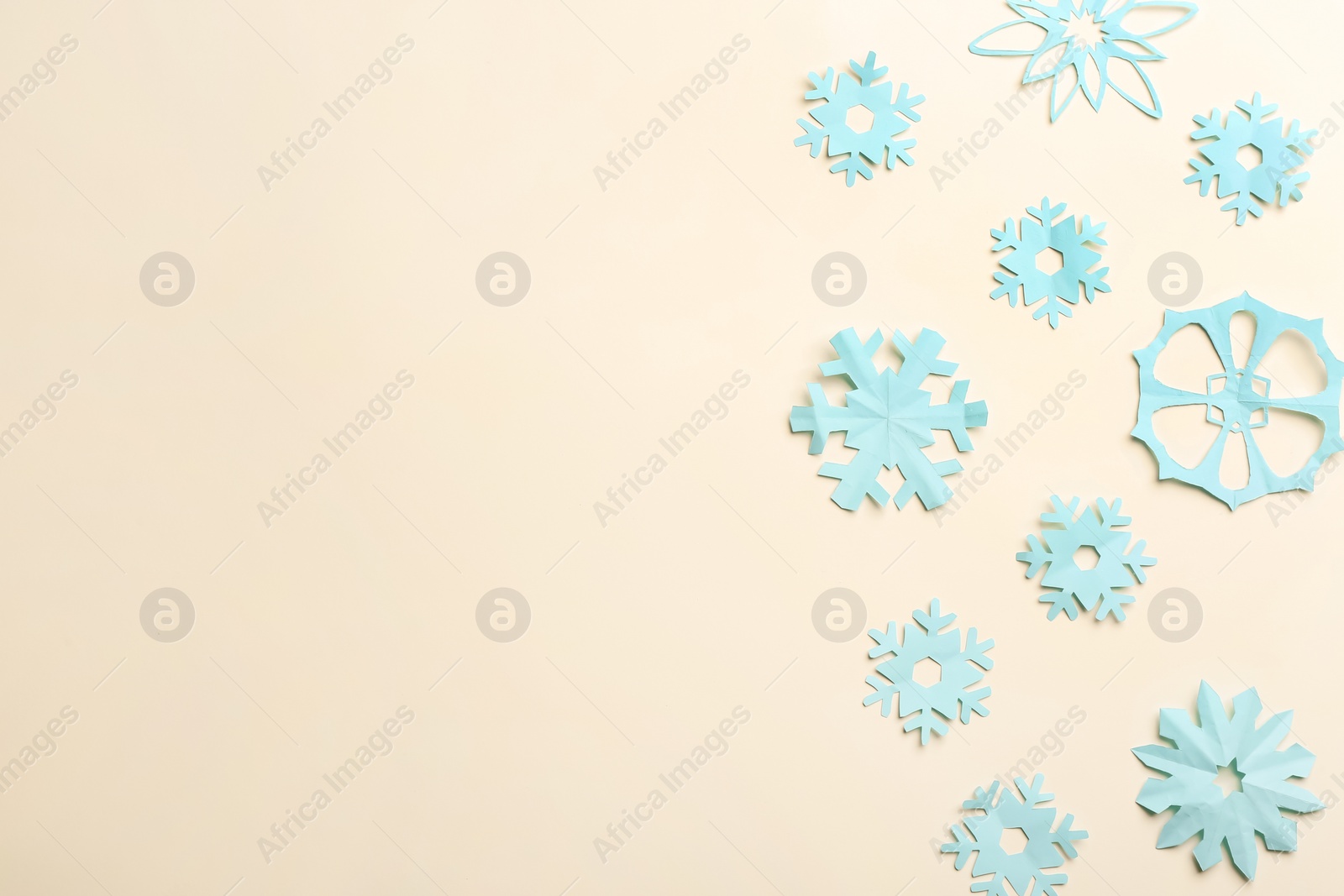 Many paper snowflakes on light background, flat lay. Space for text Photo of Many paper snowflakes on light background, flat lay. Space for text
