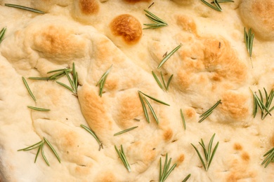 Traditional Italian focaccia bread with rosemary as background, closeup Photo of Traditional Italian focaccia bread with rosemary as background, closeup