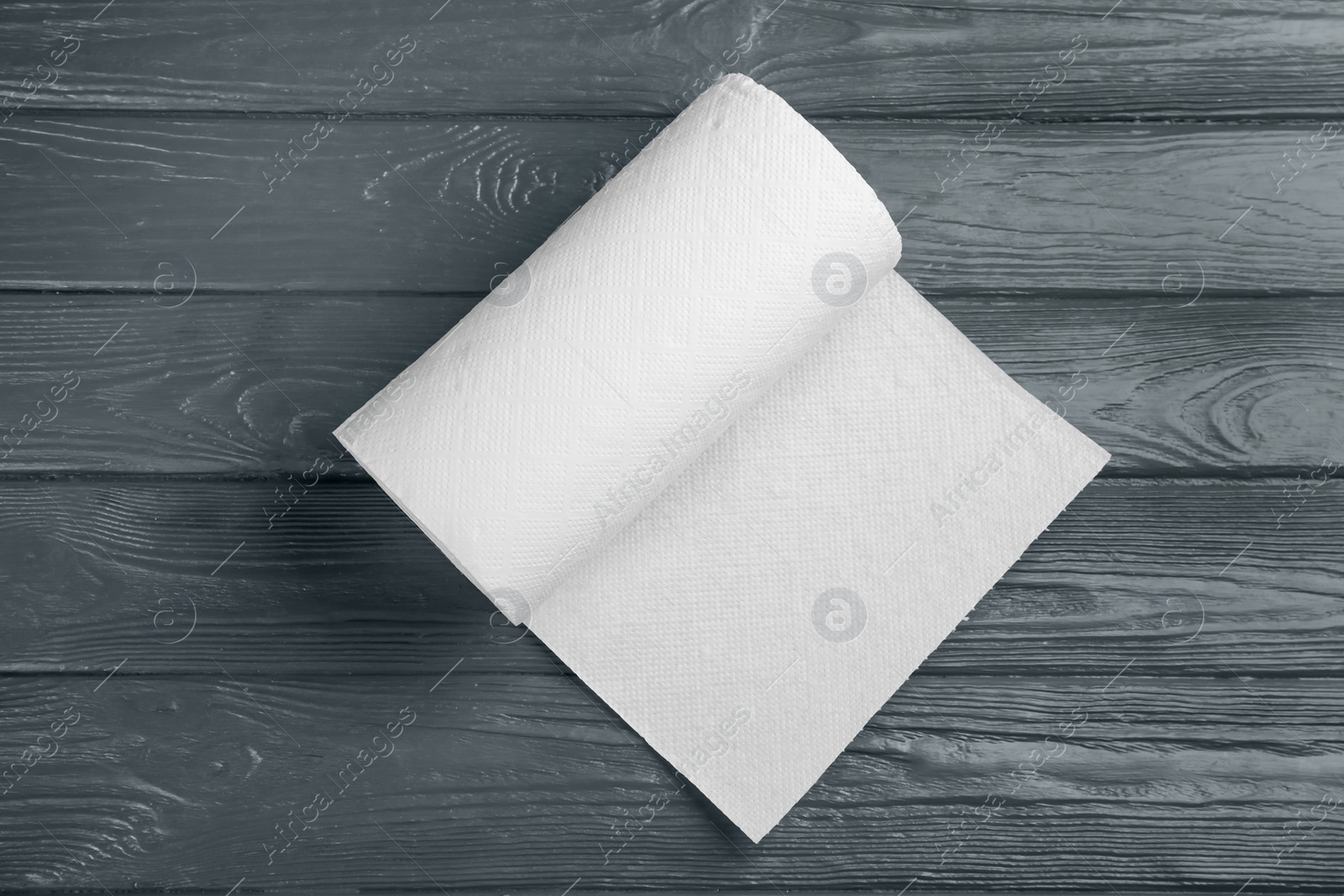 Roll of paper towels on grey wooden table, top view Photo of Roll of paper towels on grey wooden table, top view