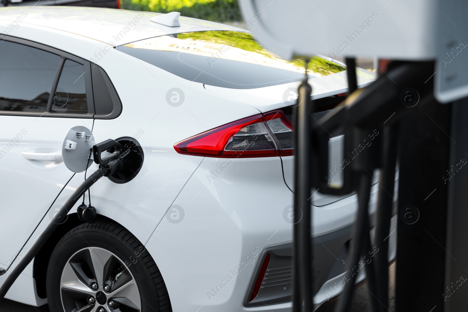 Charging modern electric car from station outdoors Photo of Charging modern electric car from station outdoors