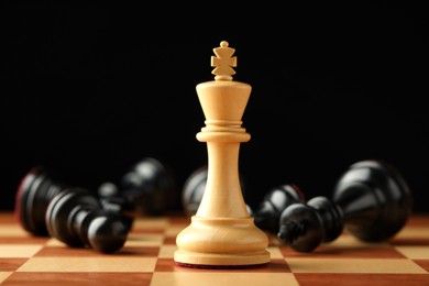 Photo of Chessboard with game pieces on black background, closeup