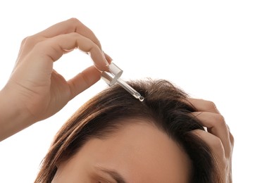 Mature woman applying oil onto hair on white background, closeup. Baldness problem Photo of Mature woman applying oil onto hair on white background, closeup. Baldness problem