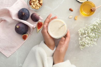 Woman with delicious fig smoothie at light table, top view Photo of Woman with delicious fig smoothie at light table, top view